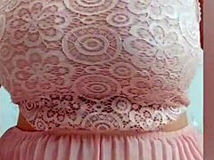 Ein charmantes Mädchen in einem rosa Kleid streichelt ihre großen Brüste vor der Kamera - depravedminx