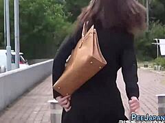 Asiatisk luder tisser på gaden foran sin kæreste
