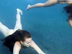 Црвенокоса девојка и плавокоса тинејџерка истражују једно друго тело у базену