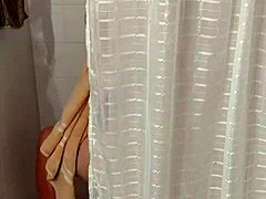 Une milf aux gros seins taquine avec une serviette après la douche
