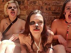 Tři nahé ženy si hrají s výstředním jazykem venku