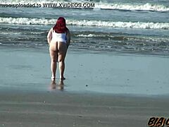 מילף עם גוף מעודן מציגה את הנכסים שלה על החוף בשמש מדהימה
